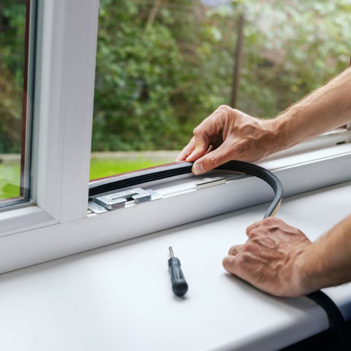 worker installing sealing tape on plastic window frame. copy space